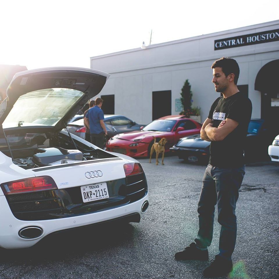 John standing beside a white Audi R8 outside the shop
