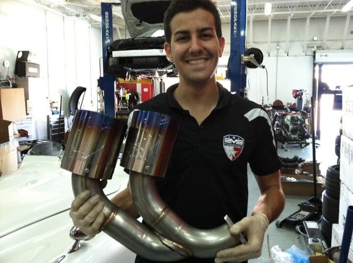 John smiling and holding a set of titanium exhaust headers